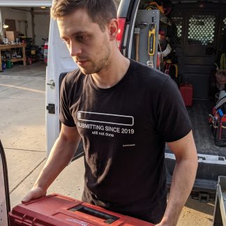 Jake Novak wearing the LOWPOWER Submitting Since 2019 statement tee, driveway loading tools scene