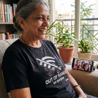 Lakshmi Iyer wearing the LOWPOWER Out of Range statement tee, video call scene